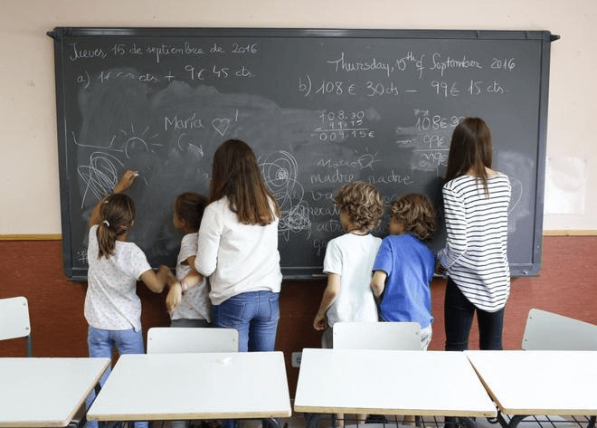 estudiantes escribiendo en el pizarrón escuela